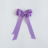 Dark orchid purple bow on a white background