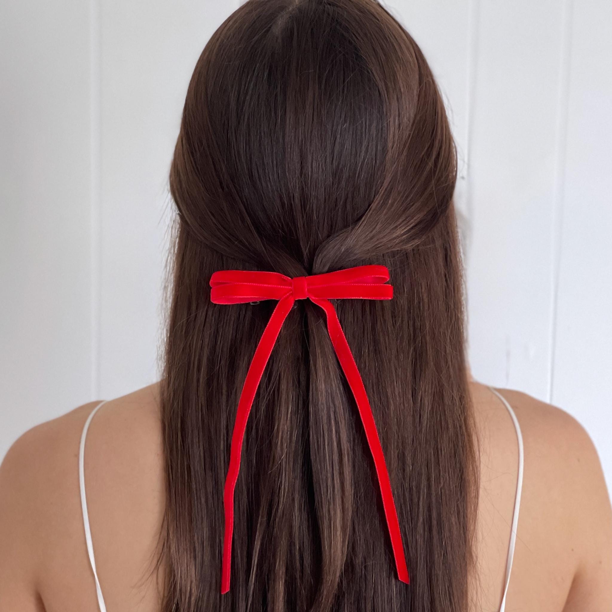 Model wearing Olivia skinny velvet bow in red.