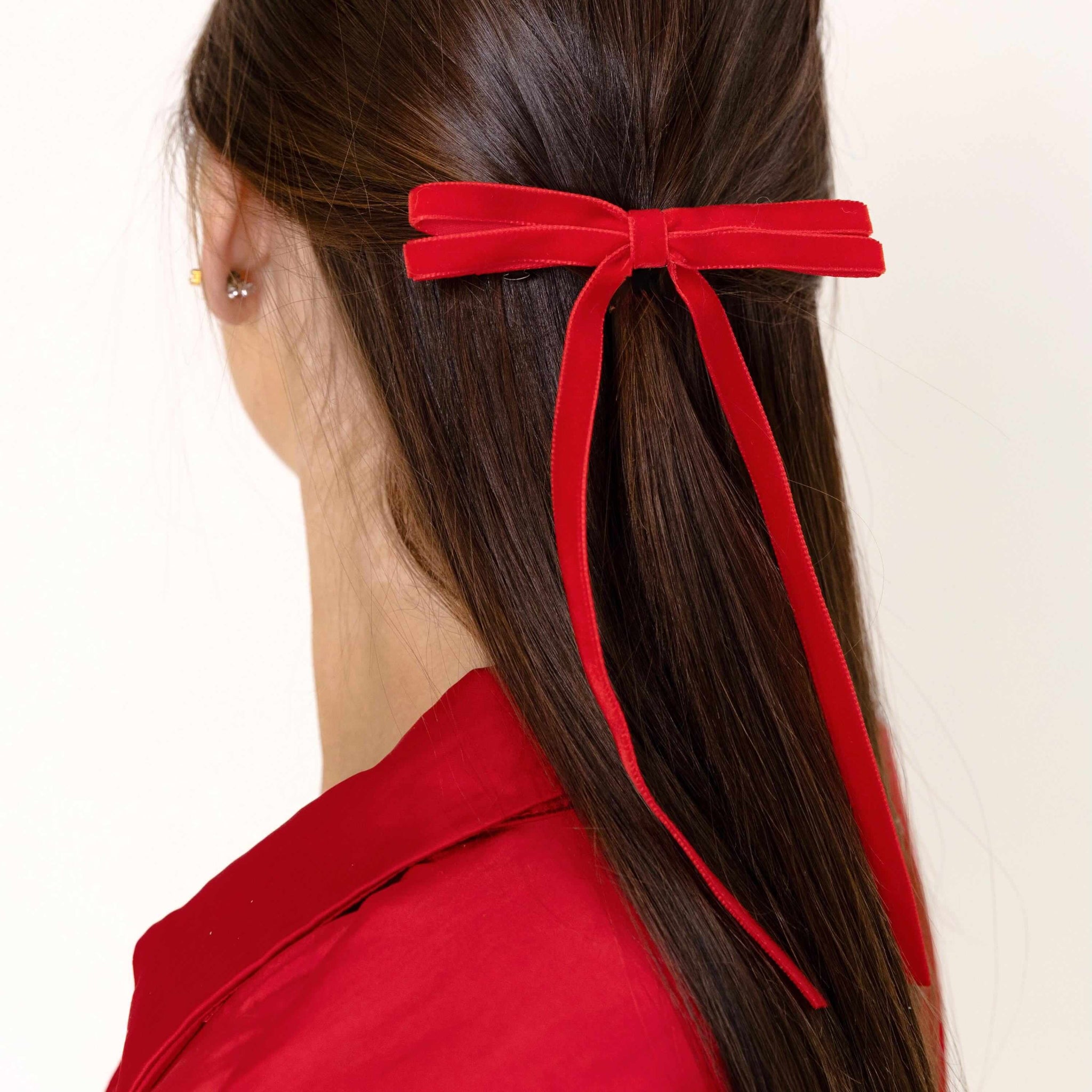 Model wearing Olivia skinny velvet bow in red.