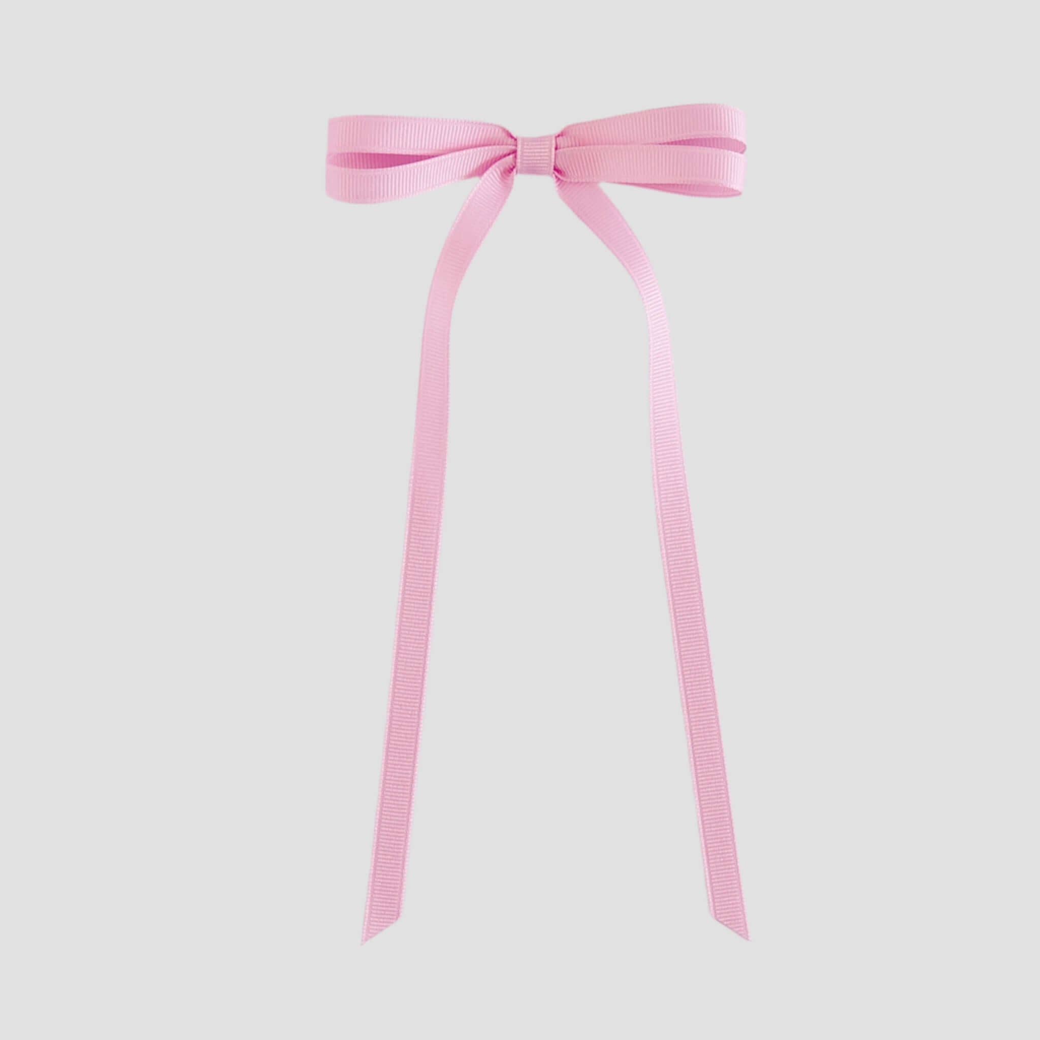 Light pink bow with long ribbons on a white background