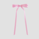 Light pink bow with long ribbons on a white background