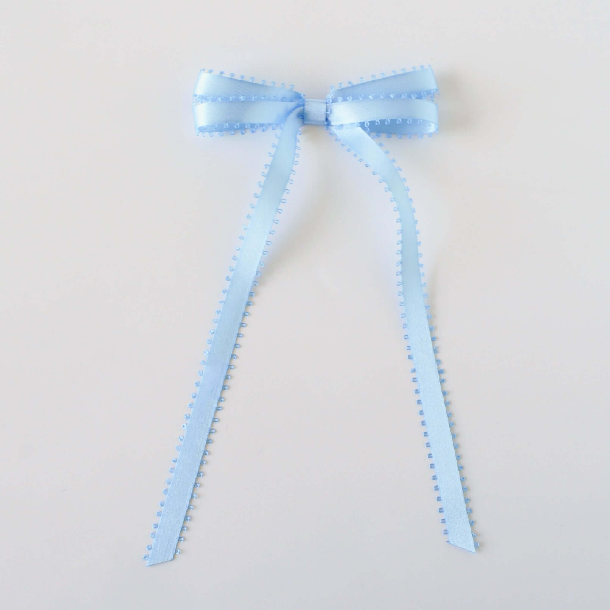 Olivia Picot Satin Bow in light blue, handcrafted with picot edges for chic hairstyles, suitable for women and girls.