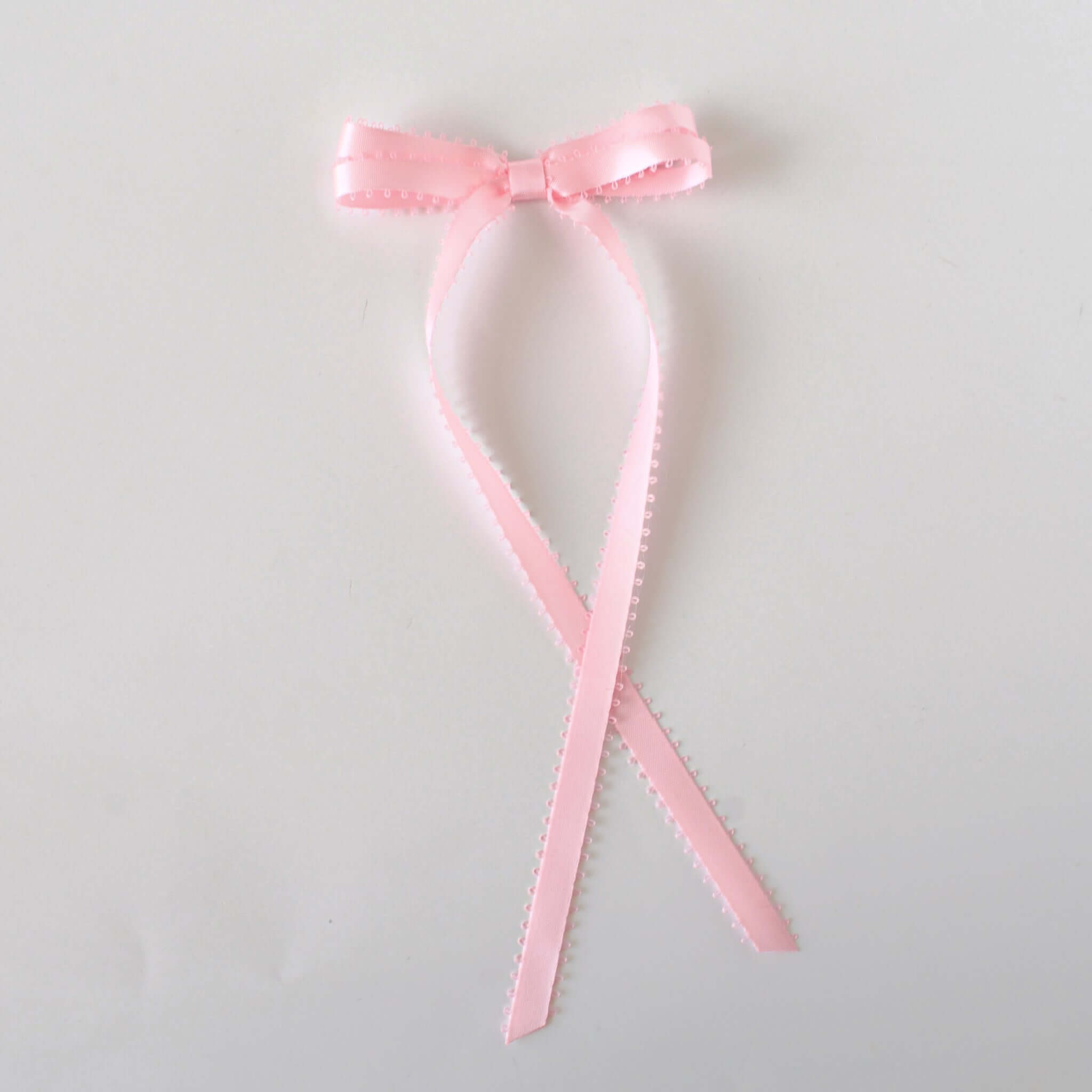 Olivia Picot Satin Bow in soft pink with picot edges, perfect for elegant hairstyles for women and girls.