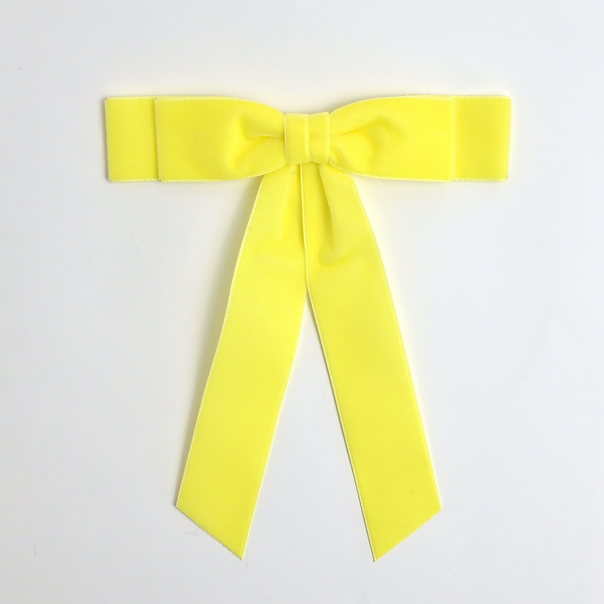 Light yellow Grace velvet hair bow for women. Double bow with long tails on white background 