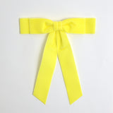 Light yellow Grace velvet hair bow for women. Double bow with long tails on white background 
