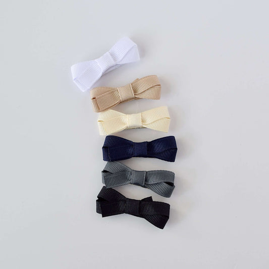 Mini hair bow set for babies and toddlers in neutral colors, featuring six grosgrain ribbon bows in white, beige, cream, navy, gray, and black.
