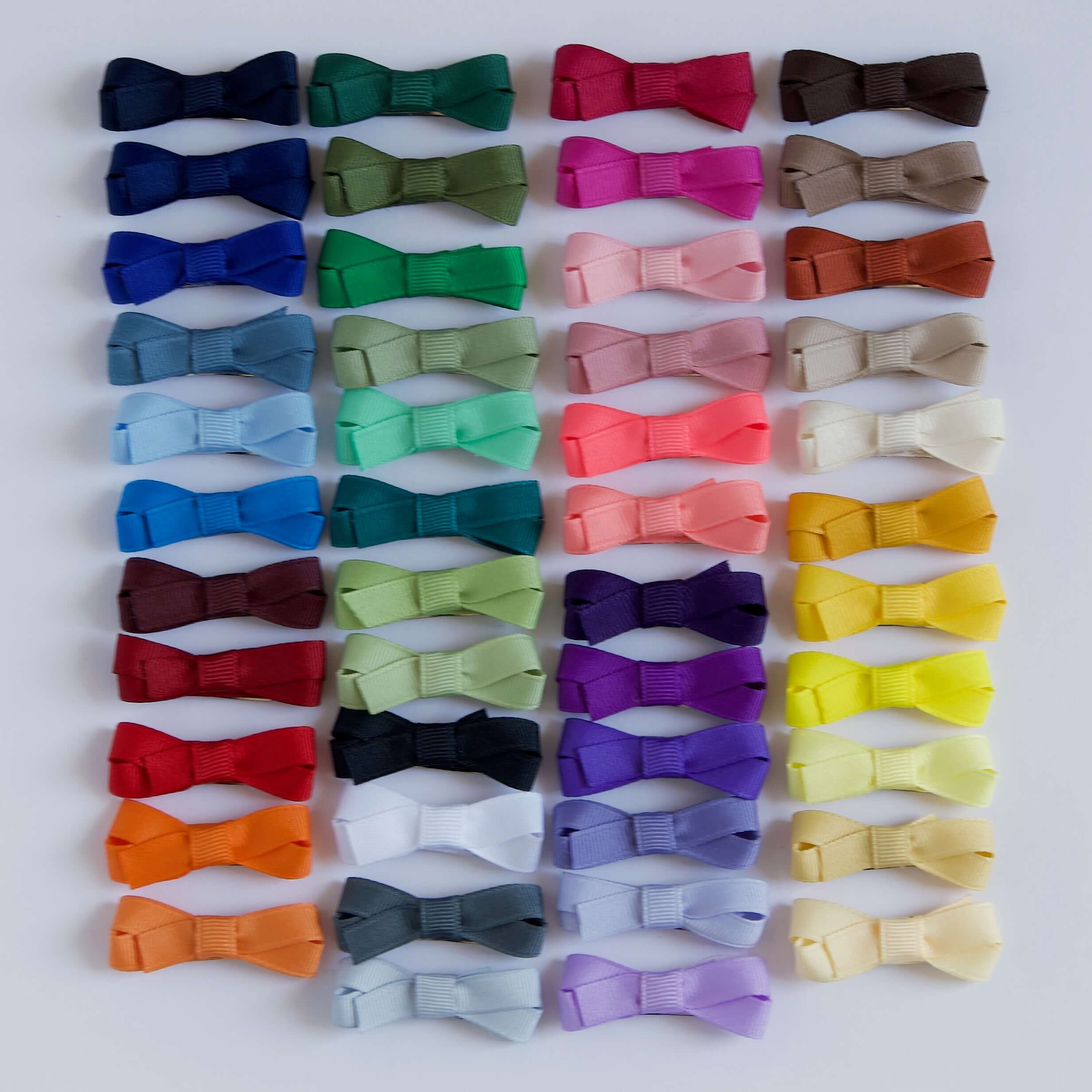 Collection of colorful bow hair clips on a white background