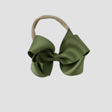 Moss green hair bow on a nude nylon headband against a white background