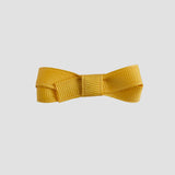 Mustard yellow bow on a white background
