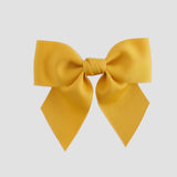 Mustard yellow hair bow on a white background