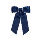 Navy blue bow with white edge on a light gray background