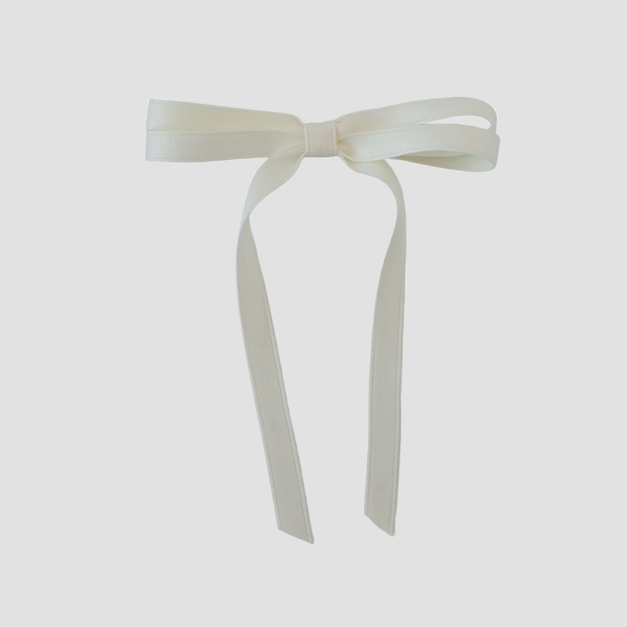 Olivia petite matte satin hair bow in ivory on a white background.