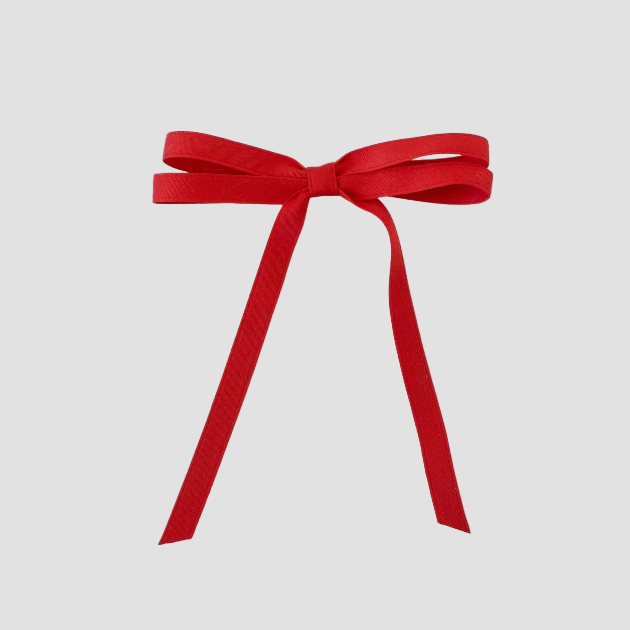 Olivia petite matte satin hair bow in red on a white background.