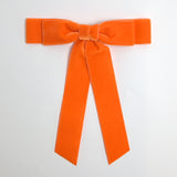Orange Grace velvet hair bow for women. Double bow with long tails on white background 