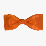 Ava satin bow in orange on a white background