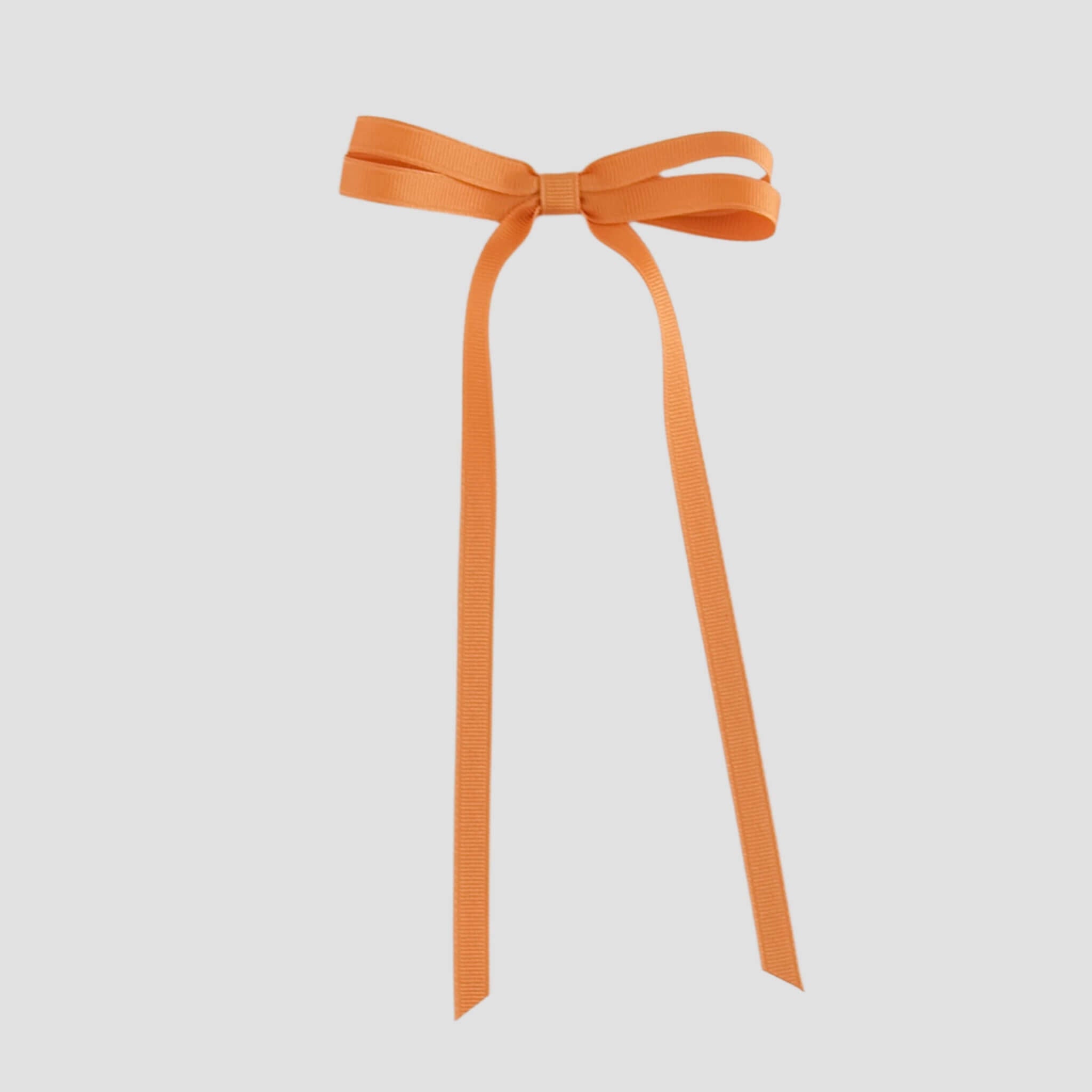Pumpkin orange ribbon bow on a white background