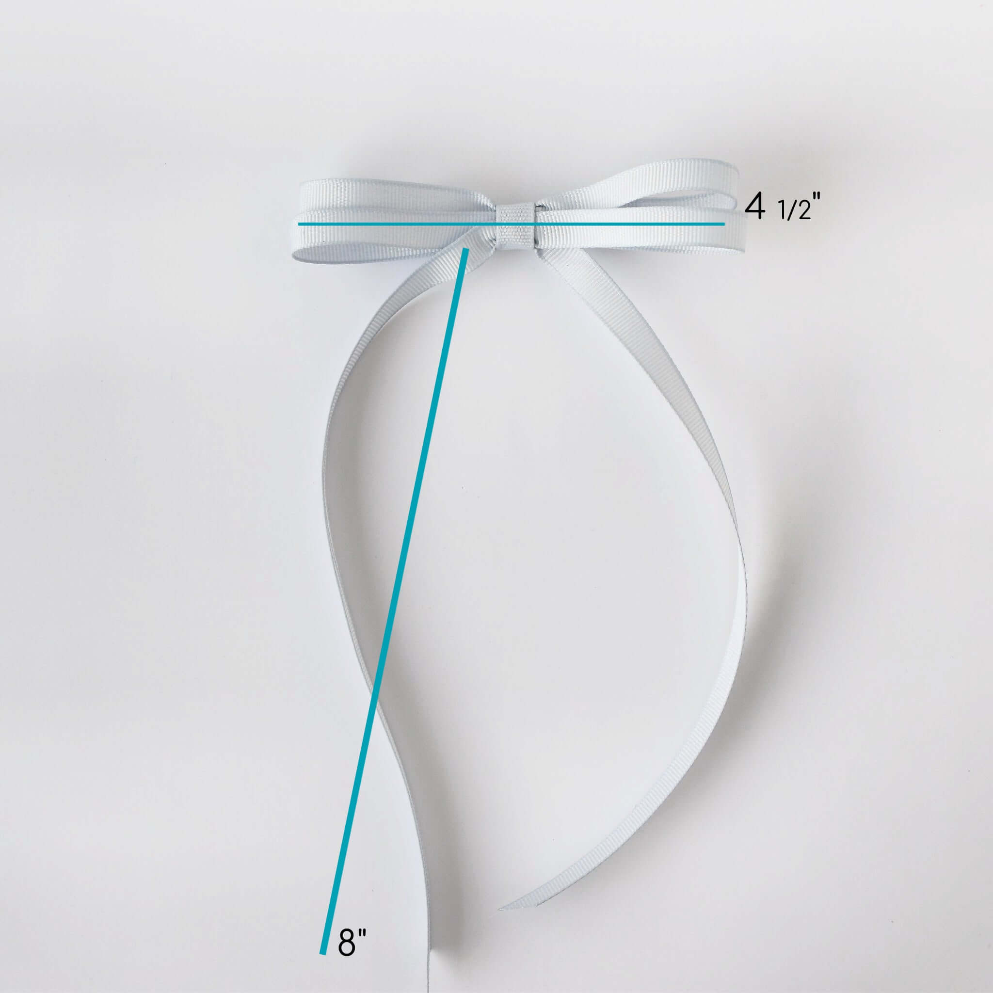 Silver bow with measurements on a light gray background