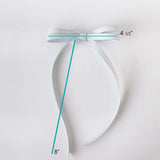 Silver bow with measurements on a light gray background