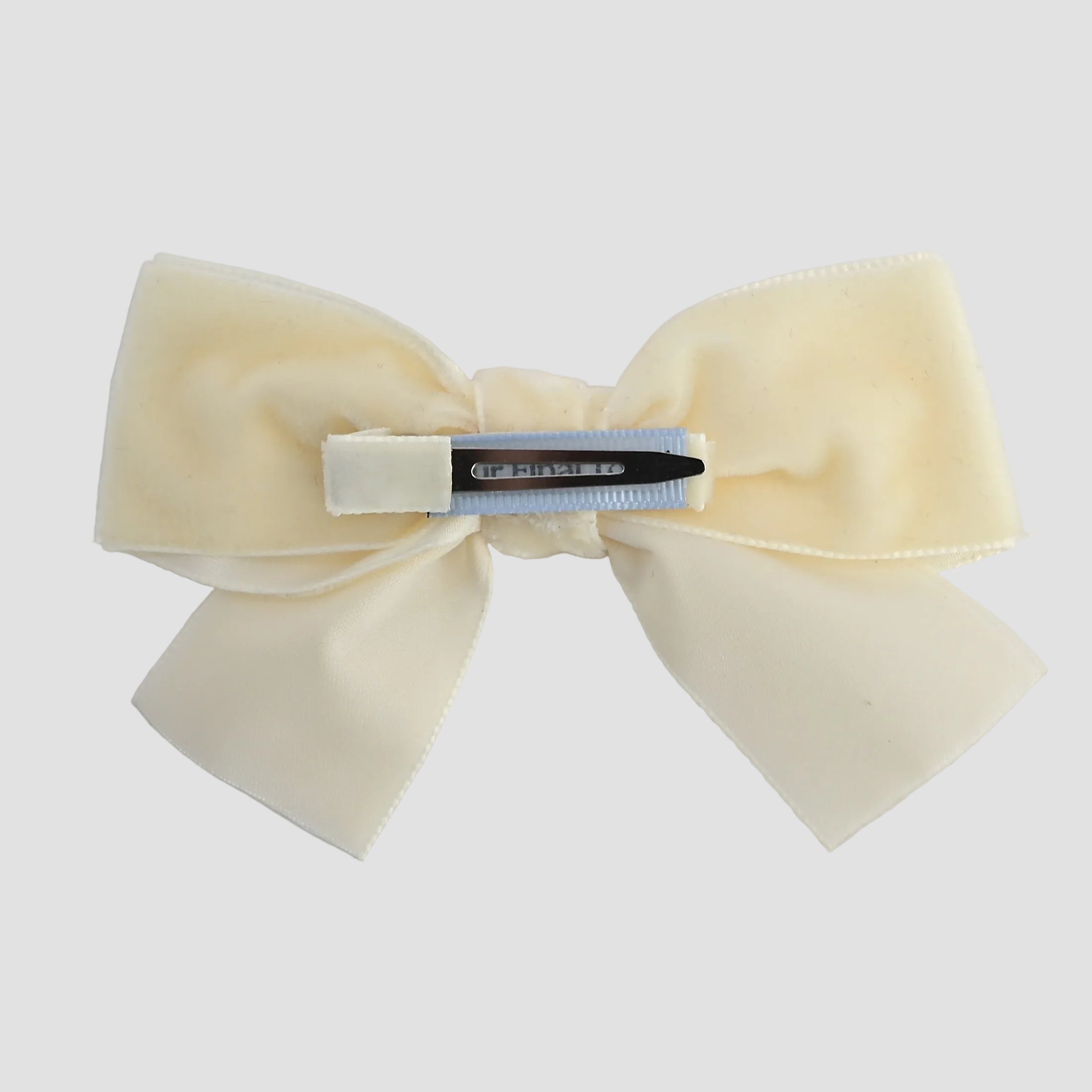 Ivory velvet kayla bow showing the alligator clip  on a white background