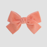 Velvet Kayla hair bow in coral on a white background