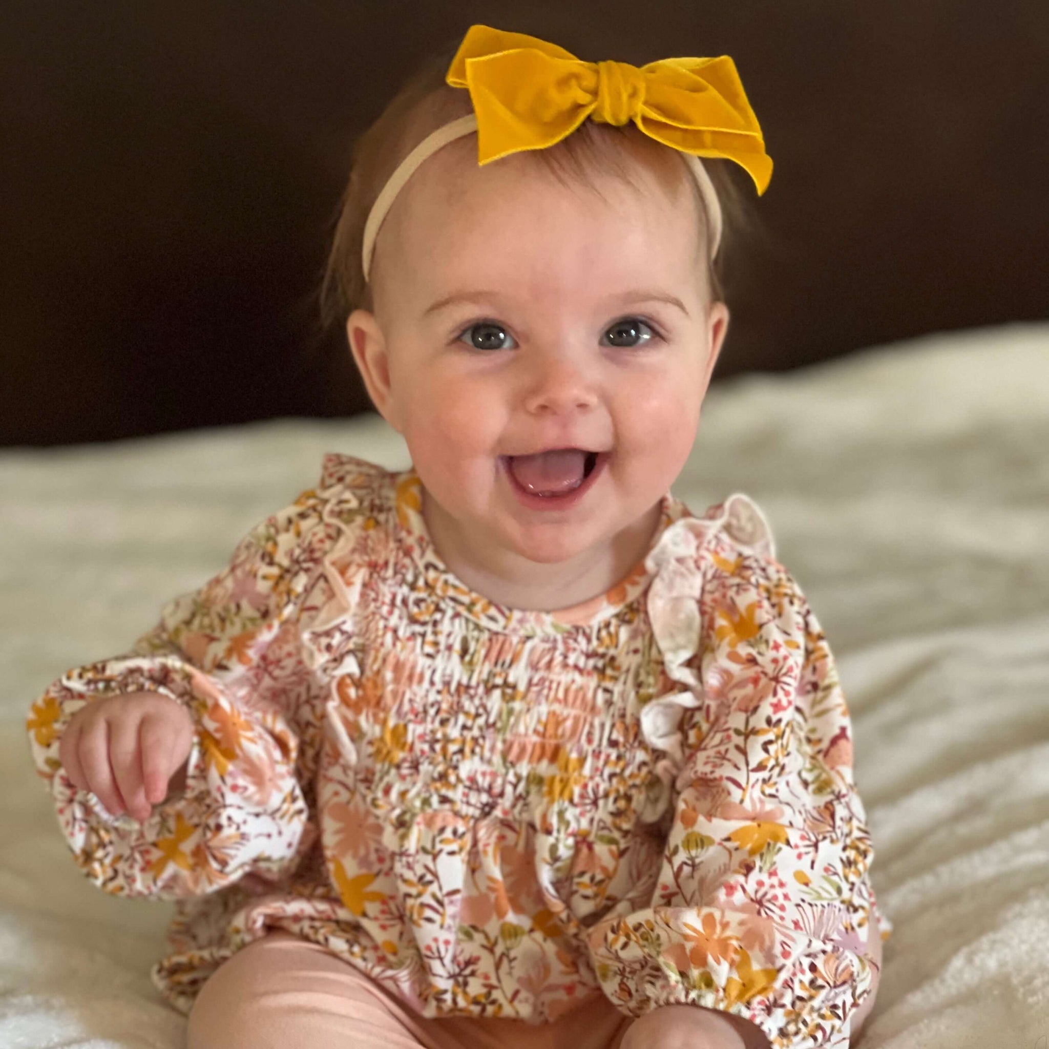 Baby wearing Kayla velvet bow headband in mustard