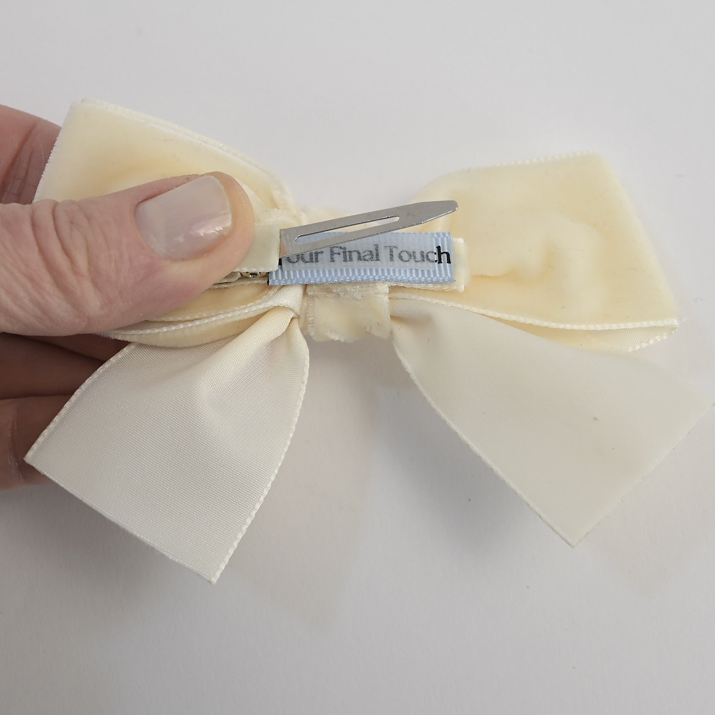 Ivory velvet Kayla bow showing alligator clip with a no slip grip on a white background
