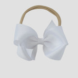White bow on a nude nylon headband against a white background