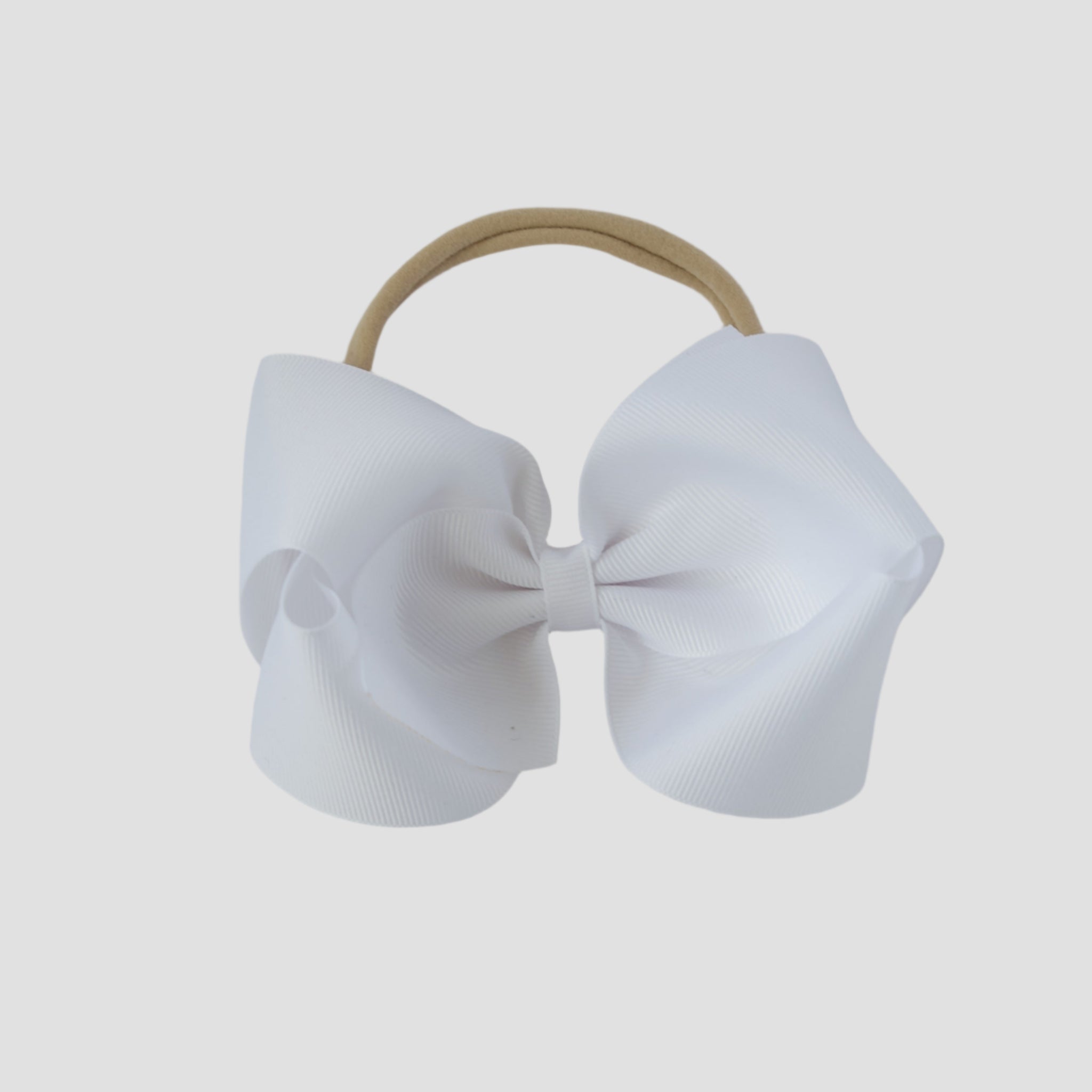 White 5 inch bow on a nude nylon headband on a white background
