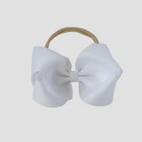 White 5 inch bow on a nude nylon headband on a white background
