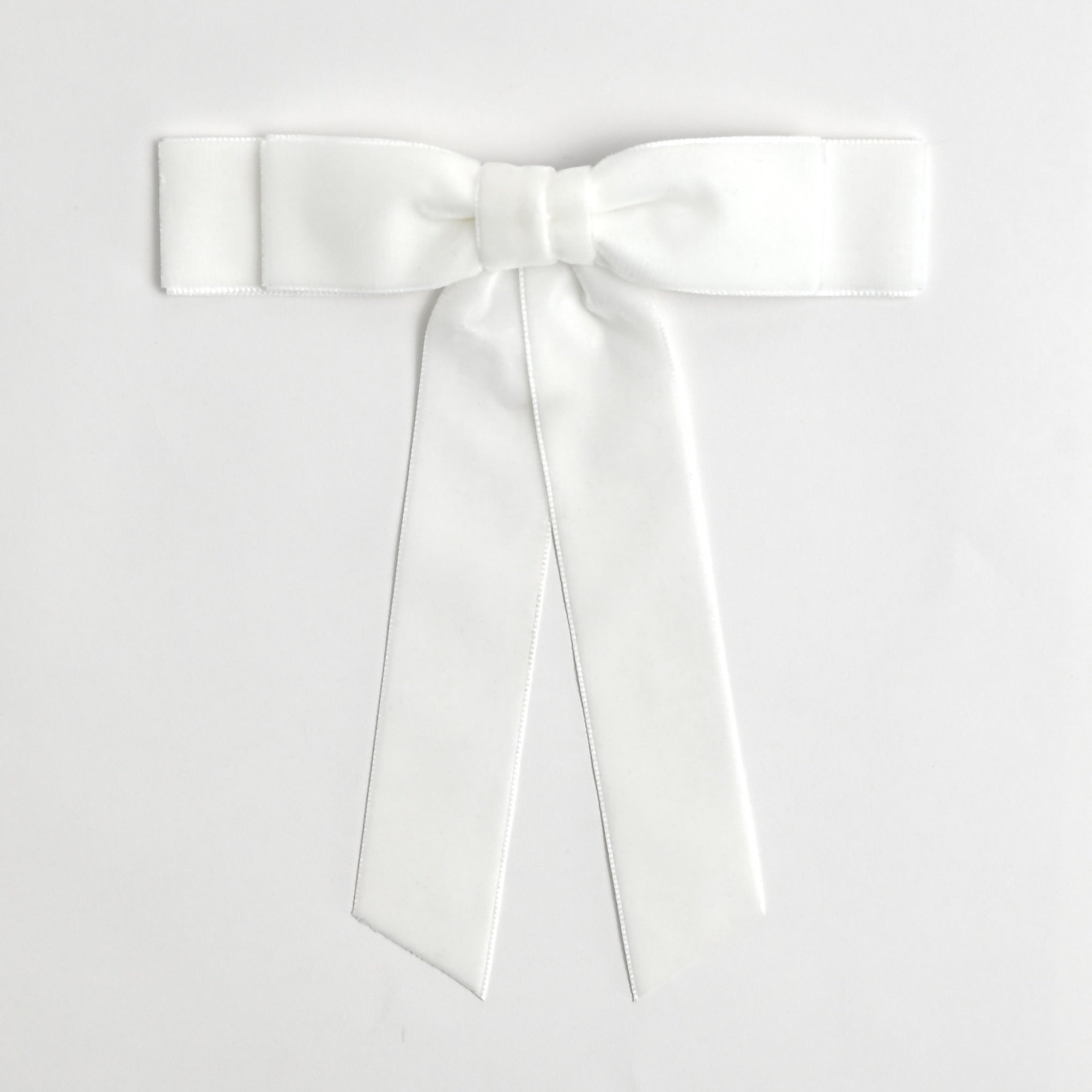 White Grace velvet hair bow for women. Double bow with long tails on white background 