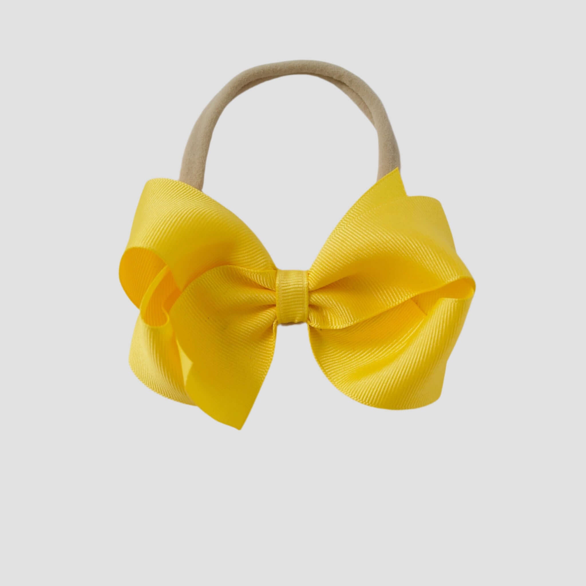 Yellow hair bow on a nude nylon headband