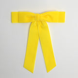 Yellow Grace velvet hair bow for women. Double bow with long tails on white background 