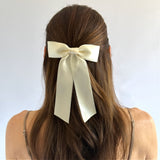 Zoe petite satin hair bow in ivory on model wearing a half up style.
